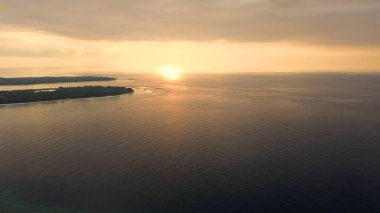 Açık okyanusta gün batımının nefes kesici görüntüsü İHA 'nın havadan çektiği görüntüler. Turuncu gün batımı ışığı, güneş okyanusta batıyor. Gün batımında gökyüzünde güzel renkler. Yüksek kalite fotoğraf