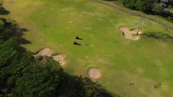 在空中看到一个人在高尔夫俱乐部的绿色草坪上打高尔夫 打高尔夫球的人的影子 富人奢侈运动的概念 高质量的4K镜头 — 图库视频影像
