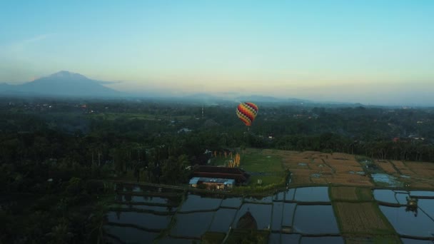水に浸かって空を反射する田んぼの中の一つの熱気球の空中観察 熱気球 日没の空を背景に — ストック動画