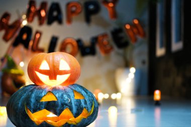 Karanlık bir odada, Cadılar Bayramı 'nın sembolü içinde mum olan bir balkabağı kafasıdır. Cadılar Bayramı partisi için dekorasyon. Cadılar Bayramı balkabağı başlıklı arka planda yanan mumları olan balkabağı feneri