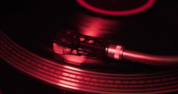 在红灯照明下 乙烯唱机中的针头滑过乙烯唱片的宏观视频 舒适的氛围与乙烯播放器 — 图库视频影像