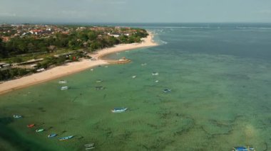Bali adasında yer alan Sanur sahilinin havadan görünüşü. Beyaz kum, okyanus ve şehir manzarası. Sanur sahilinde İHA uçurmak. Turistik eğlence, Bali 'nin en iyi plajları..