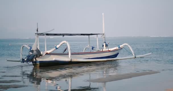 一艘渔船停泊在岸上 一艘木船停靠在海岸附近的海面上 小波浪摇曳着小船 闪烁着闪烁的光芒 风景如画的海景 — 图库视频影像