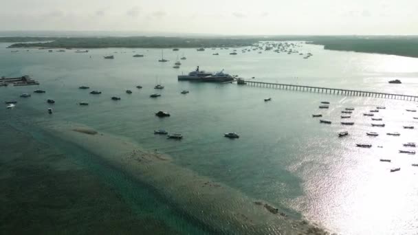 バリ島のサヌールの港の空中ビュー 釣りと観光ボートは海岸に駐車しています ヨットは海を航行する 人気の観光地 ラグジュアリーな水上輸送と旅行 — ストック動画