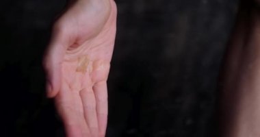 Duşta duş jeli sıkan ve ellerini sabunlayan bir kadının dikey videosu. Kadın avuçlarında duş jeli ve sabun dokusundan köpük. Günlük hijyen, vücudunla ilgilenmek..