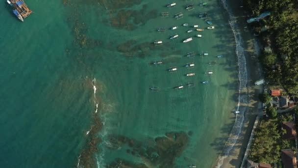 巴厘岛Padang Bai港口的空中景观 许多小船停泊在海湾沿岸 潜水游览船和离岸渔船 码头船只航行的港口中的码头 — 图库视频影像