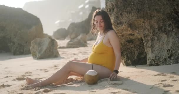 Średnie Ujęcie Ciężarnej Kobiety Żółtym Stroju Kąpielowym Siedzącej Plaży Wśród — Wideo stockowe