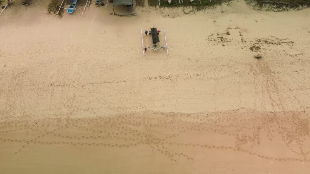 漁船を引っ張っている砂浜の空中展望 漁師は水の中にボートを打ち上げました 小さな熱帯諸島の水上輸送 — ストック動画