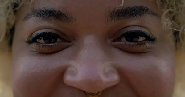 Close-up of the eyes of a young African American woman looking at the camera and smiling. Portrait of an African woman smiling with her eyes, positive energy.