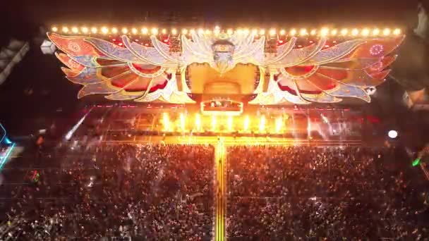 バリで行われた大規模な音楽フェスティバルの空中観察 群衆はステージでDjが演奏する音楽に踊る 夜のステージと美しい景色にライトショー — ストック動画