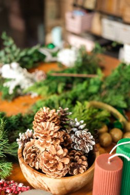 Noel arkaplanı köknar dalları, kozalaklar ve mumlarla dolu. Noel çelengi yapıp evde süslemek. Yeni yıl için süslemeleri kendi ellerinle hazırlıyorsun, usta sınıf..