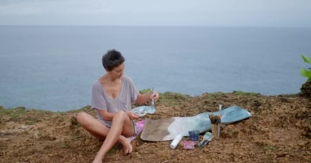 Artystka Siedzi Klifie Nad Oceanem Maluje Obraz Krajobrazowy Życia Malarstwo — Wideo stockowe