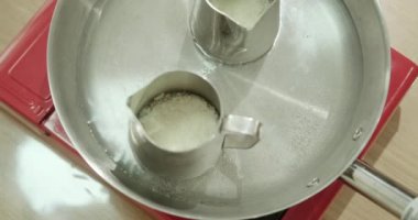 Usta sınıfında mum yapma sürecinin en üst görüntüsü. Kavanozlardaki soya gevrekleri, balmumunu eritmek için sobanın üzerine konur. Mumları doldurmak için balmumu eritiyoruz. Üretim süreci.