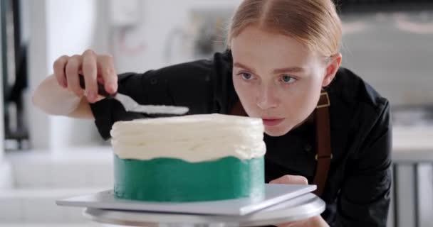 Retrato Una Joven Pastelera Pelirroja Que Mira Pastel Con Concentración — Vídeo de stock