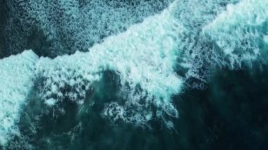 Beyaz köpüklü büyük dalgaların olduğu koyu mavi okyanus suyunun üst görüntüsü. Meditasyon ve yoga için okyanustaki dalgalarla arka plan videosu. İnsansız sörf kavramı.