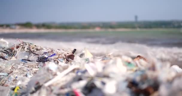 一个被塑料垃圾污染的海滩的特写镜头 全球环境灾难 海滩上堆积如山的垃圾来自海洋 空的使用肮脏的塑料瓶和其他化学废物 — 图库视频影像