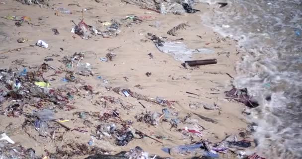 沙滩被塑料垃圾污染了 全球环境灾难 海滩上堆积如山的垃圾来自海洋 废物在水里漂浮 避免使用塑料袋和塑料瓶 — 图库视频影像