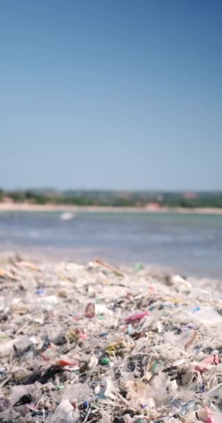被塑料垃圾污染的垂直沙滩 全球环境灾难 海滩上堆积如山的垃圾来自海洋 废物在水里漂浮 避免使用塑料袋和塑料瓶 — 图库视频影像