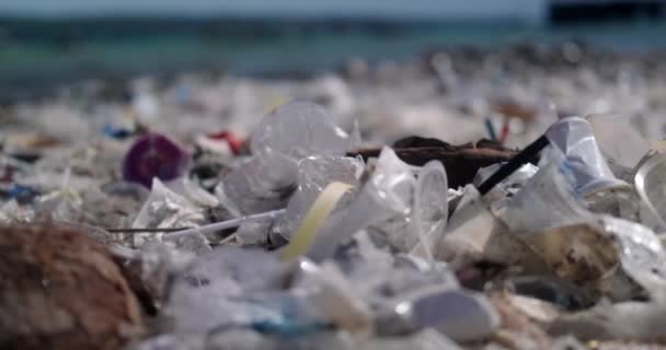 一个被塑料垃圾污染的海滩的特写镜头 全球环境灾难 海滩上堆积如山的垃圾来自海洋 空的使用肮脏的塑料瓶和其他化学废物 — 图库视频影像