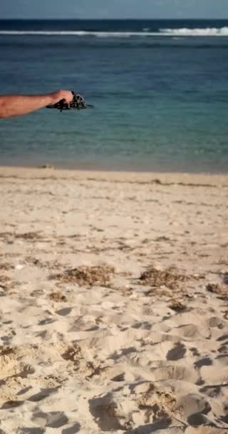 垂直な男が海の近くのビーチでFpvドローンを起動する ドローンは砂に落ちてはじまらず 壊れている 機器に関する問題 サービスセンター — ストック動画