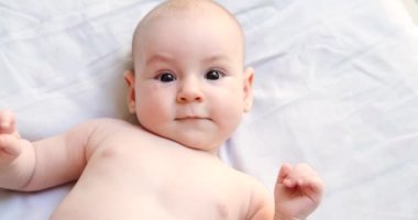 4 aylık bir bebeğin, battaniyeye uzanmış, şaşkınlık içinde etrafa bakıp kahkahalar atan portresini yakından çek. Annesinin oynadığı duygusal yeni doğan bebek. Mutlu çocukluk anları. Anneler Günü.