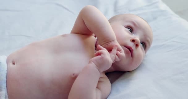 코카서스 아기의 초상화 기저귀에 가벼운 담요에 소녀는 놀라움 신생아의 감정을 — 비디오