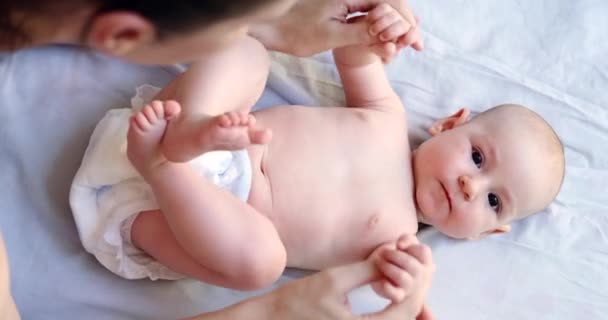 Bebé Pañal Acuesta Sobre Una Manta Ríe Madre Levanta Las — Vídeo de stock