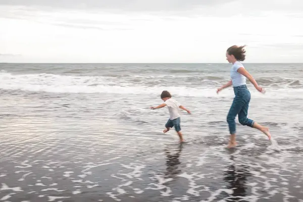 Mama Syn Toddler Biegają Wzdłuż Czarnego Piasku Wzdłuż Oceanu Śmieją Obraz Stockowy