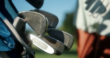 Profesyonel golfçü bir kadının, golf çantasından golf sopası seçerken çekilmiş yakın plan fotoğrafı. Golf oynamak için spor malzemeleri. Şehir Kulübü.