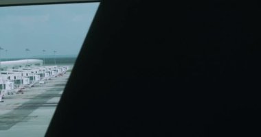 Bir uçağın kalkışa hazır olduğu havaalanındaki pistin penceresinden bakın. Yolcular için yürüyen merdivene ateş eden ilk kişi. Dışarısı bulutlu, hiç insan yok..