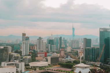 Şehir manzarası ve Kuala Lumpur, Malezya 'daki gökdelenler. Bulutlu ve sisli havada şehrin dramatik manzarası. Uzun gökdelenler ve doğa ile birleşen modern binalar. Asya metropolü.