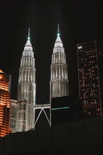 stock image Vertical Petronas Towers at night Kuala Lumpur, Malaysia. The two tallest towers in Asia glow in the dark. Popular tourist attraction. Shopping center KLCC.