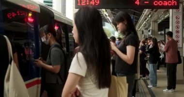 Malezya, Kuala Lumpur 'daki RapidKL tren istasyonu. Şehirde hızlı bir toplu taşıma aracı. Birçok farklı insan arabaya girer. İşe gitmek için acele ediyorlar. Bir metropolde toplu taşıma trafiği.