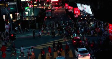 Meşgul Bukit Bintang Caddesi Kuala Lumpur, Malezya. Birçok insan karşıdan karşıya geçiyor. Araba trafik lambasının yeşil yanmasını bekliyor. Sokak neon ışıklarıyla aydınlatılmış ve fütüristik görünüyor..