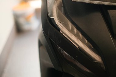 Bir kazadan sonra kırılan mobilet farını kapat, kafa kafaya çarpışma. Kazadan sonra motosiklet hasarı. Olağanüstü spor sigortası. Motosiklet tamiri. Araçlar tamir ediliyor.