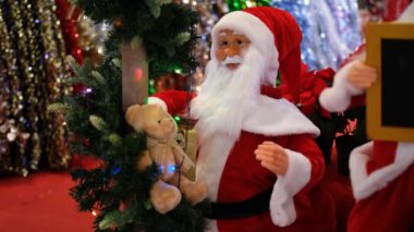 Noel indirimi sırasında alışveriş merkezinde hareket eden ve konuşan oyuncak Noel Baba. Tatil alışverişi. Yeni yıl için hediyeler ve alışveriş.