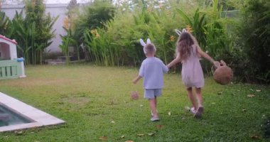 Paskalya çocukları yeşil çimlerde yumurta avına çıkar. Çocuklar yumurta arayışında koşar, onları bir sepette toplar ve şenlikli dekorasyonların arka planında eğlenirler. Aile gelenekleri.