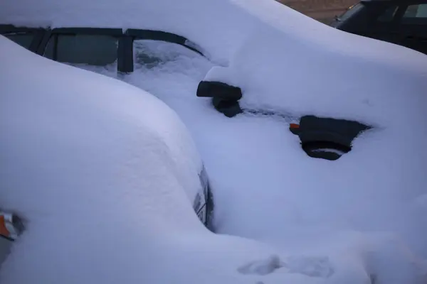 Kış otoparkı. Kar tabakasının altındaki arabalar. Kentsel zorluklar. Kış taşımacılığı ve ulaşım kavramı.