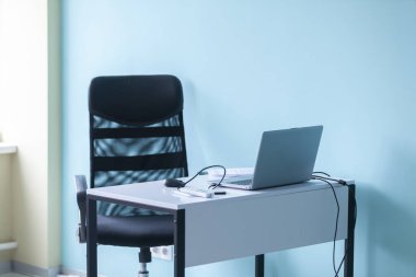 Ofiste boş iş yeri: dizüstü bilgisayar, masa ve koltuk.