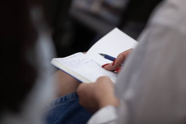 Not defterine not alan bir kadın. Yakın plan. Seçici odak.