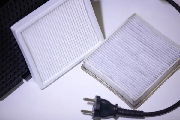 Elektrik süpürgesi için yeni ve eski beyaz kare toz filtresi. Elektrik süpürgesi filtresi değiştiriyorum. Yakın plan..