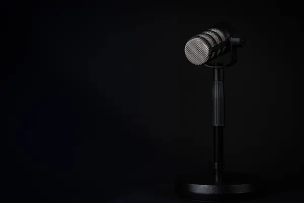 Podcast ya da ses kaydedici mikrofon. En düşük ışıklandırma, yatay fotoğraf, kopyalama alanı.