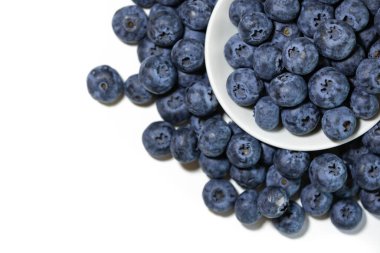 Beyaz arka planda bir kasede olgun yaban mersininden bir yudum. Tasarım amaçlı bir sürü kopya alanı sunuyor..