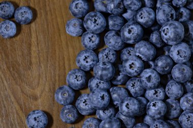 Tahta masadaki olgun yaban mersinlerine yakın çekim, zengin doku ve doğal detaylar..