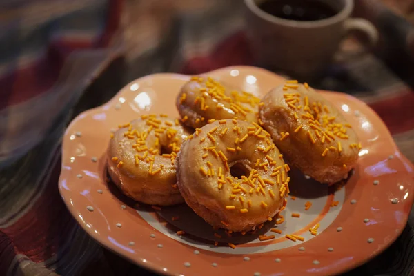 Orange glazed donuts with orange sugar sprinkles and coffee. High quality photo