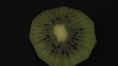 Siyahta dönen taze kivi meyvesi dilimi. Yüksek kalite 4k görüntü