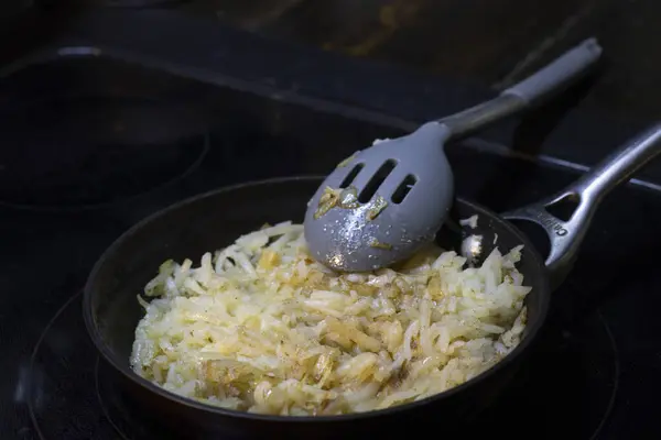 キャストアイアンフライパンで調理するシュレッドハッシュブラウン 高品質の写真 — ストック写真