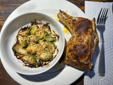 Kızarmış tavuk budu çeyreği kızarmış brussel lahanasıyla servis edilir. Yüksek kalite fotoğraf