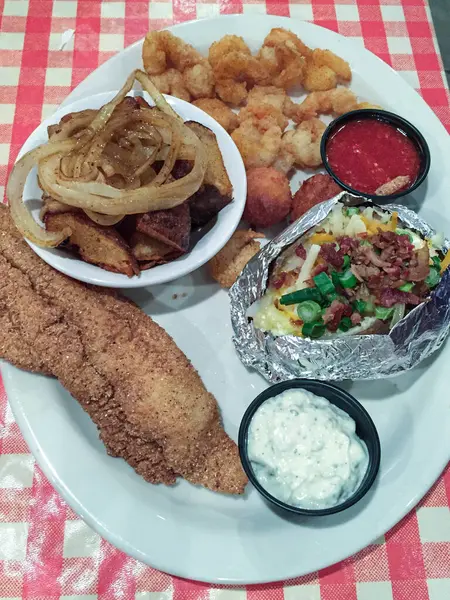 Plated fried catfish dinner with sides. High quality photo