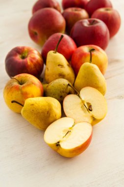 Taze elmalar ve armutlar masada yatıyor.